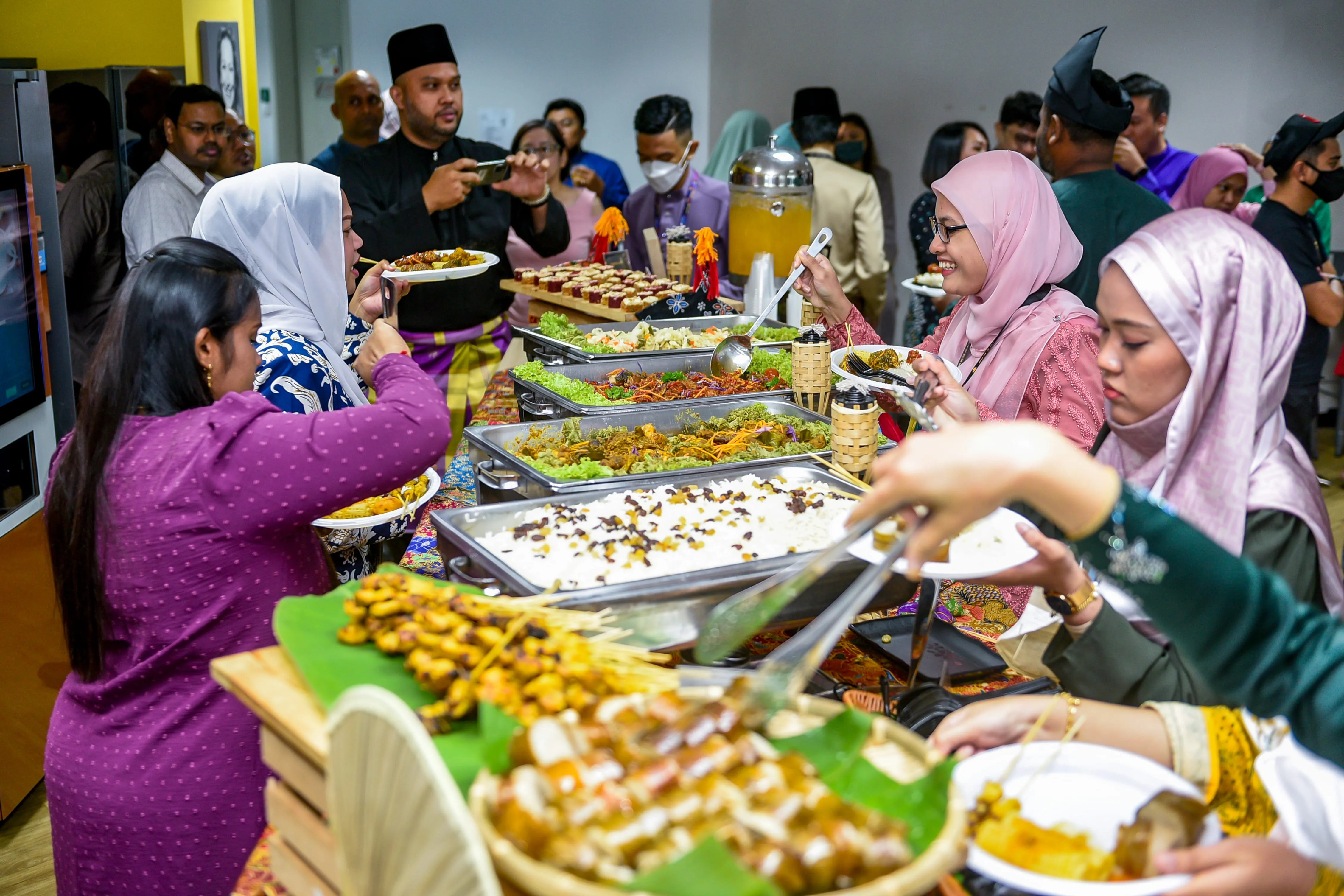 Corporate celebration buffet with guests serving themselves from chafing dishes