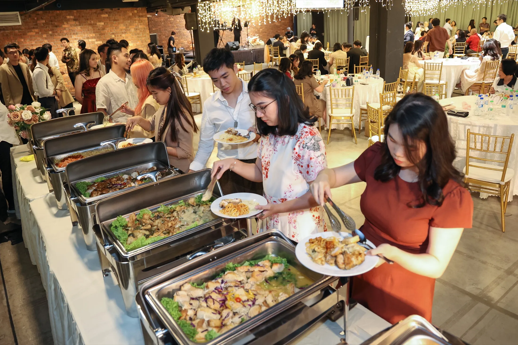 Wedding reception guests being served buffet catering from chafing dishes