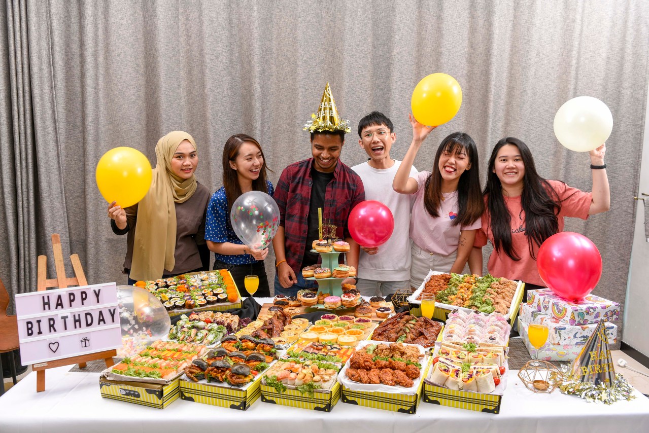 A bunch of people celebrating birthday  with runningmen foodie box
